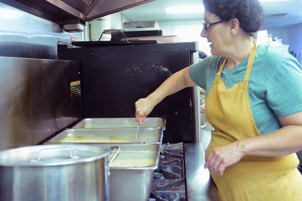 Kitchen manager Amy Bradford stirs a steaming pot of baked potato soup for lunch on Wednesday July 29th. Amy cooks all the meals at Food and Shelter from scratch with whatever donated food is available. PHOTO BY: Sierra Brown