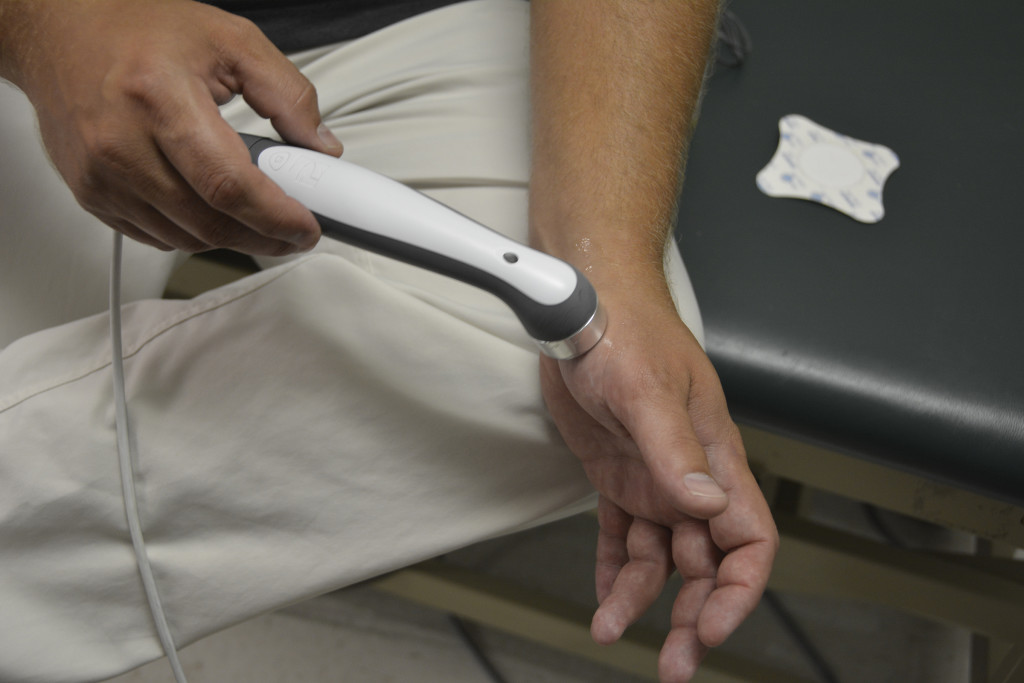 Physical Therapist Matt Miller demonstrates on his hand how they use the ultrasound tool as a thermal modality with the dexamethasone, which is a steroid anti-inflammatory prescription grade gel. Miller uses this to essentially heat up the tissue before starting to work with it. 